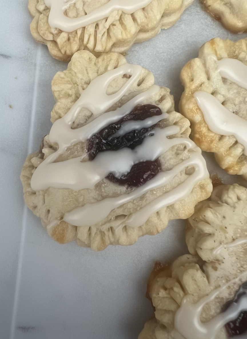 handpie with white icing and a filling on a surface